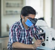 Portrait Of Students With Looking Through Microscope In A Laboratory